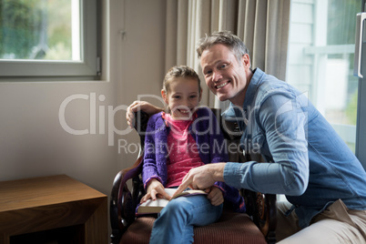 Father and daughter reading a book at home