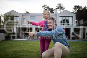 Father and daughter pointing in the garden