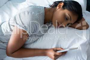 High angle view of woman using phone on bed