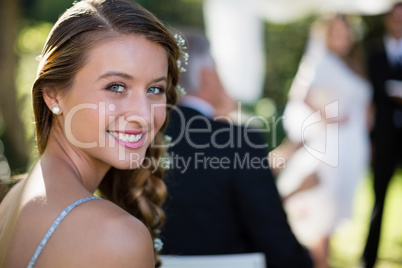 Portrait of beautiful bridesmaid smiling in park