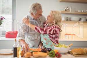 Senior couple embracing each other in kitchen