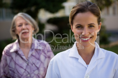 Portrait of female doctor with woman at park