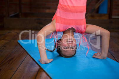 Happy teenage girl performing headstand