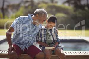 Grandson and grandfather using mobile phone