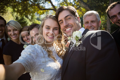 Happy couple posing with guests during wedding