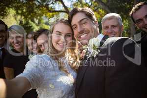 Happy couple posing with guests during wedding