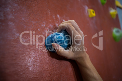 Athlete practicing rock climbing in fitness studio