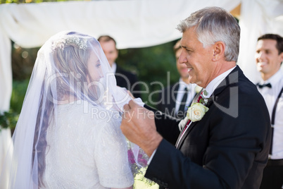 Happy father removing veil of his daughter