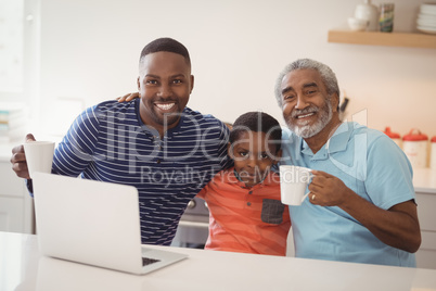 Happy multi-generation family having cup of coffee in kitchen