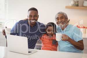 Happy multi-generation family having cup of coffee in kitchen
