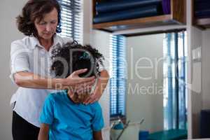 Physiotherapist giving neck massage to girl patient