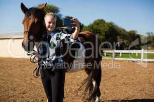 Girl taking a selfie with horse