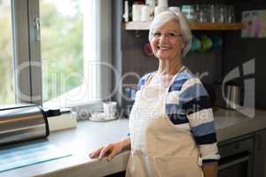 Senior woman standing near the kitchen counter