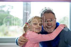 Girl and father dressed as fairy embracing each other