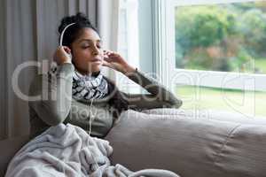 Woman with eyes closed listening to music