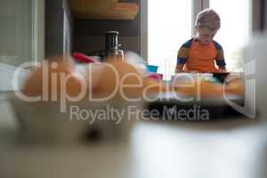 Boy using tablet at kitchen counter