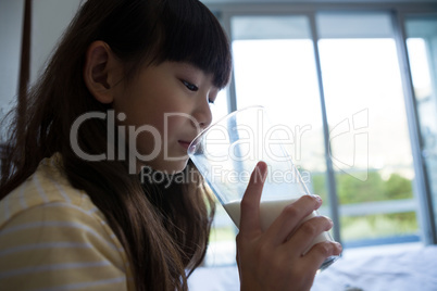 Girl drinking milk on bed