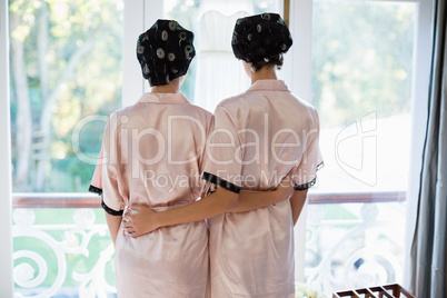 Rear view of women standing near window