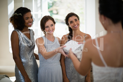 Bride receiving gift from bridesmaid