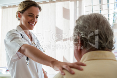 Doctor talking to senior man in retirement home