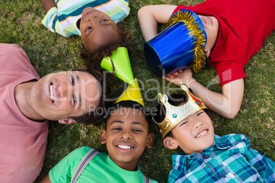 Overhead view of man with children lying on field