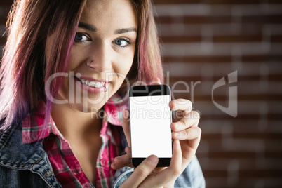 Portrait of smiling woman showing mobile phone