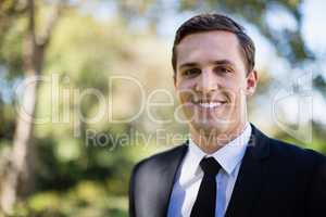 Happy groom standing in park