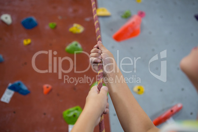 Boy practicing rope climbing in fitness studio