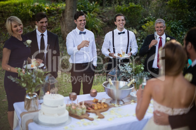 Guests and newly wedding couple having glasses of champagne