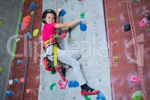 Portrait of confident teenage girl practicing rock climbing