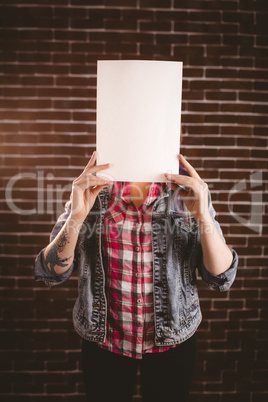 Woman hiding face from blank sheet