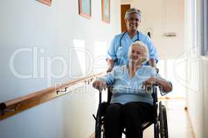 Nurse pushing patient sitting in wheelchair at nursing home