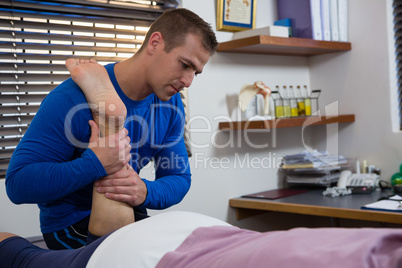 Physiotherapist giving leg massage to a woman