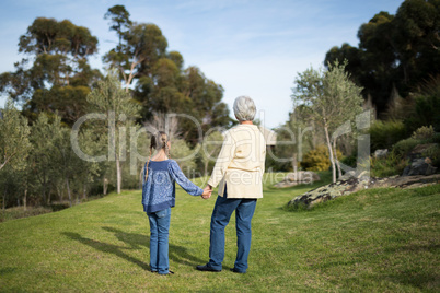 Granddaughter and grandmother standing together in garden