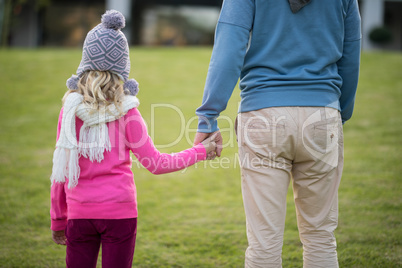 Father and daughter holding hands in the garden