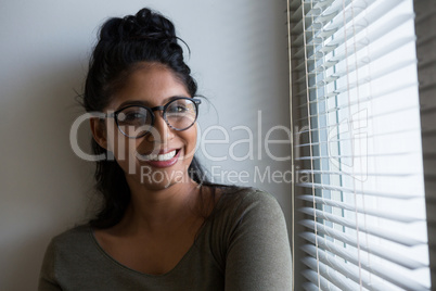 Portrait of smiling woman by window