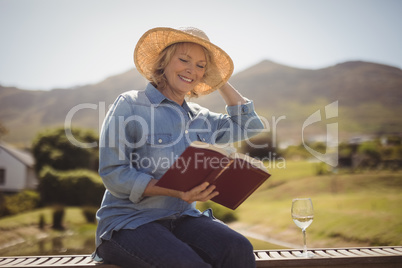 Senior woman reading a book on park bench