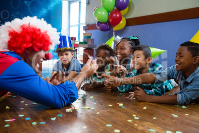 Clown showing feather to children