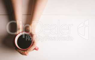 Womans hand holding coffee cup