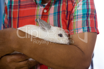 Midsection of senior man holding rabbit