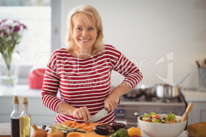 Senior woman chopping vegetables at home