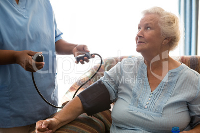 Nurse examining patient in nursing home