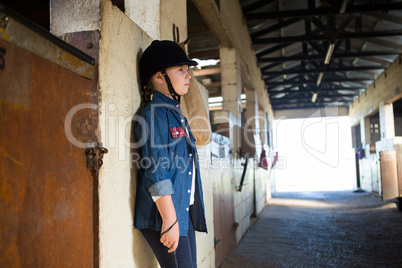 Girl leaning on wall in the stable