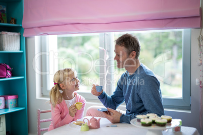 Father and daughter playing a tea set role play