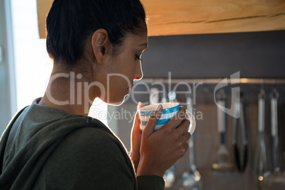 Woman having coffee in kitchen