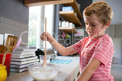 Boy mixing batter at counter