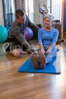 Physiotherapist assisting senior woman in exercise