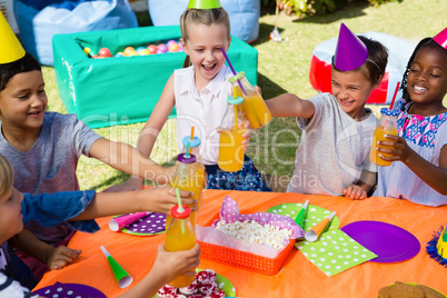 High angle view of children toasting drinking bottles