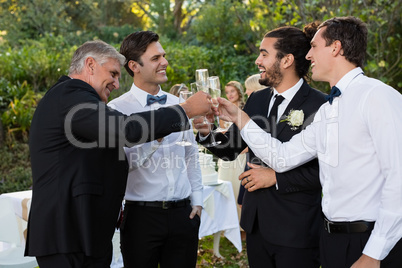 Groom and guests toasting glasses of champagne