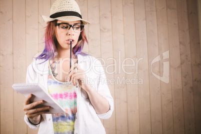 Thoughtful woman holding notepad and pen